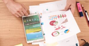 A birds eye view of a tablet and marketing documents on a desk