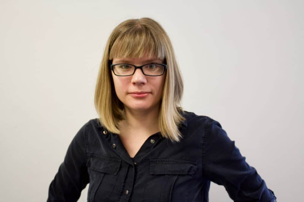 Dr Tanya Kant standing in front of a grey background