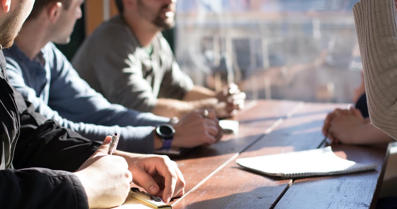 A group of people around a table taking notes