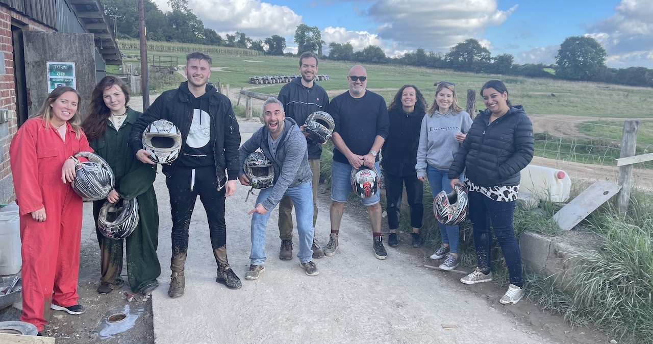 The Magenta team standing together after going quad biking on their team trip