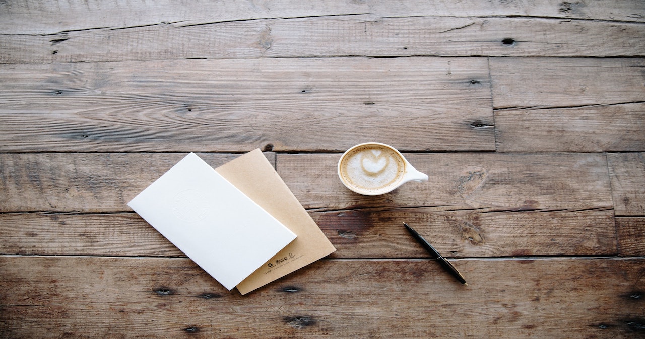 A letter and cup of coffee on a table