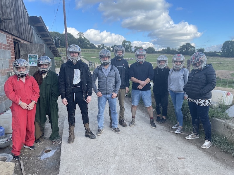 Magenta team with helmets on posing for a photo after quad biking