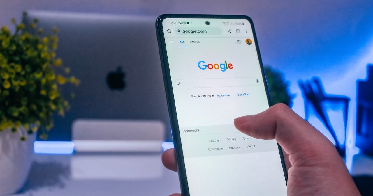 A person holding a phone with Google Search on the screen