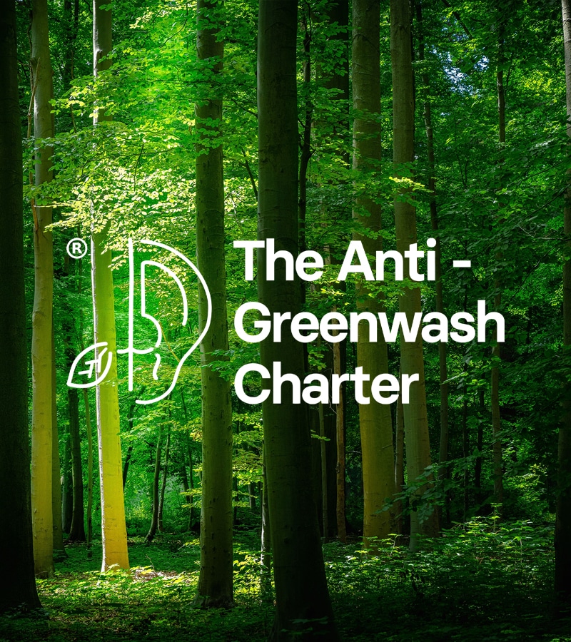 A picture of a forest with the words 'The Anti-Greenwash Charter' in white font